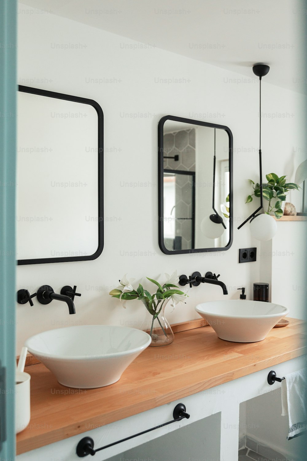 a bathroom with two sinks and mirrors on the wall