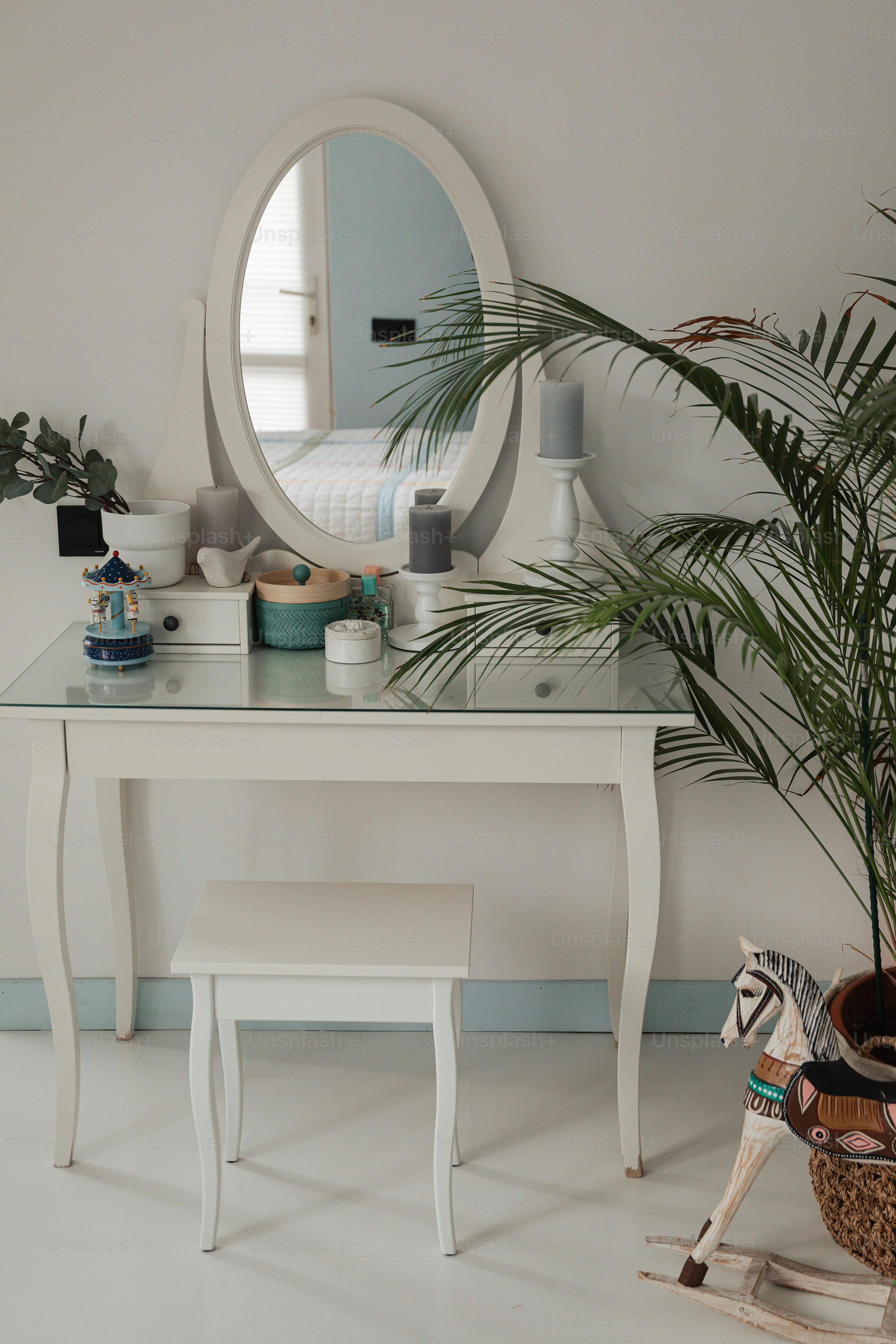 a white dressing table with a mirror and stool
