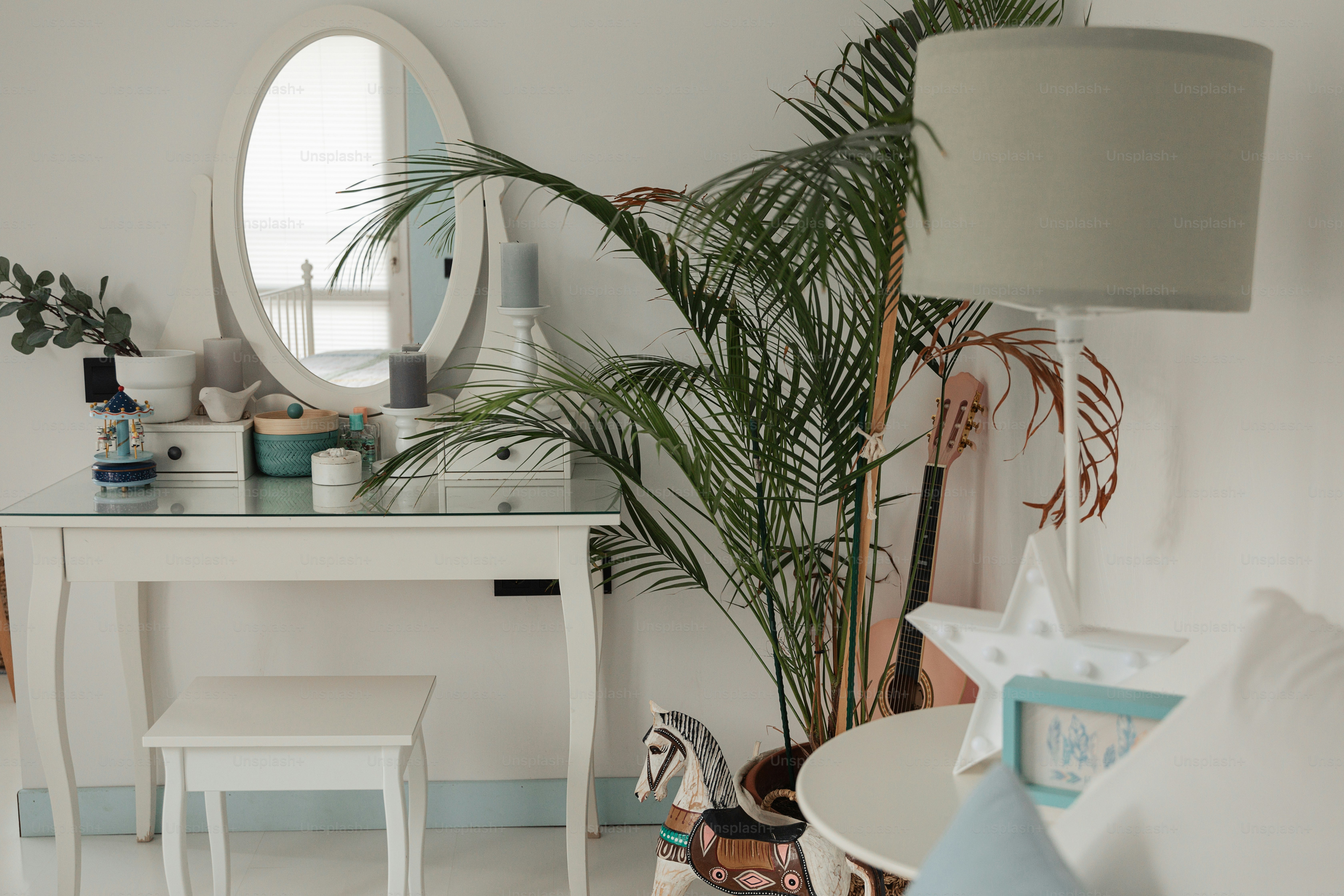 ein weißer Schreibtisch mit Spiegel und Stuhl