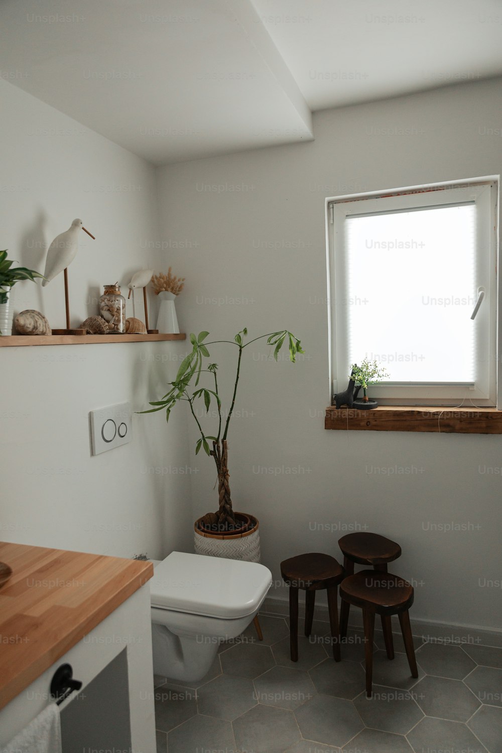une toilette blanche assise à côté d’une fenêtre dans une salle de bain