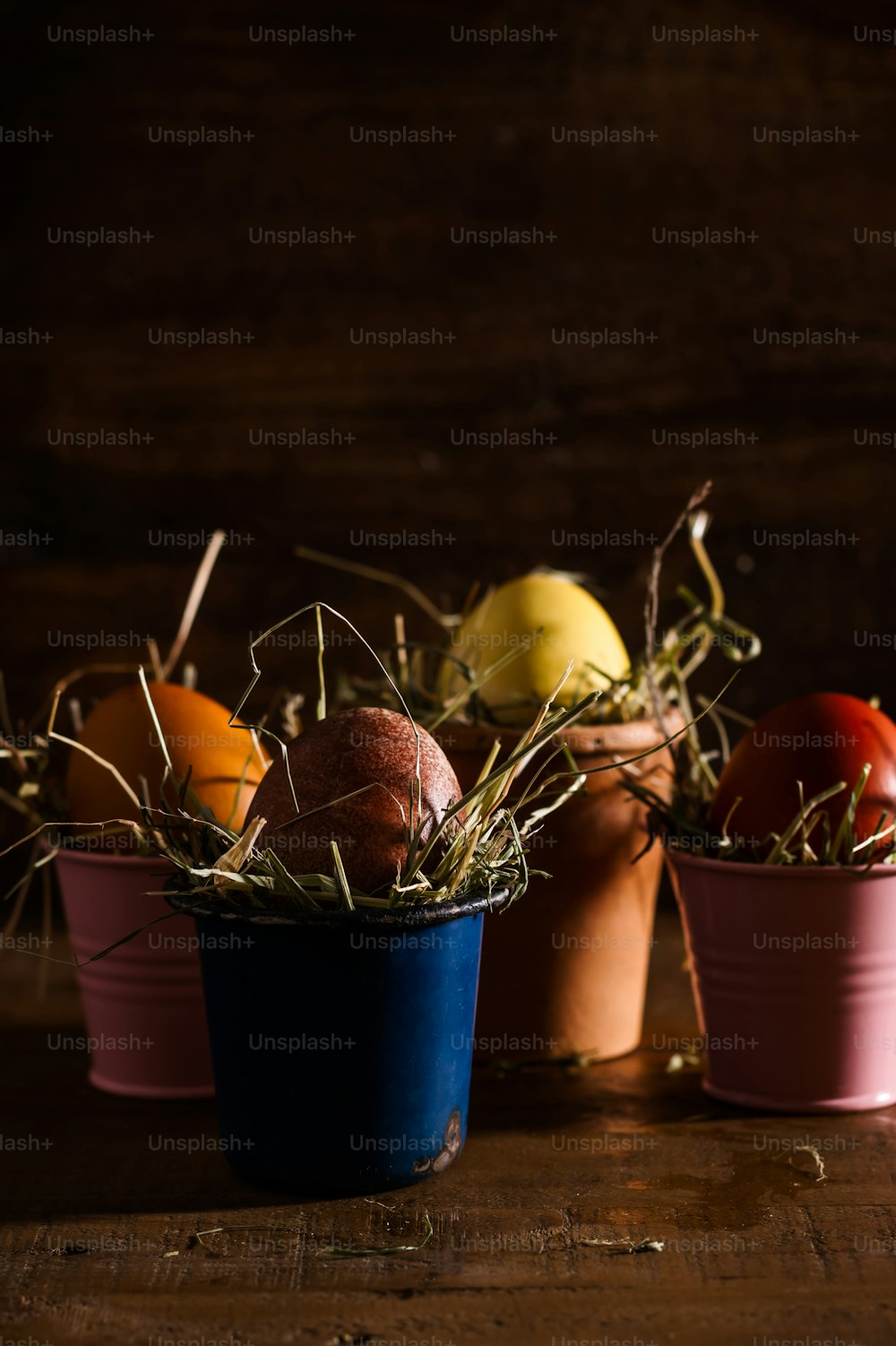 a group of three buckets filled with eggs on top of a wooden table