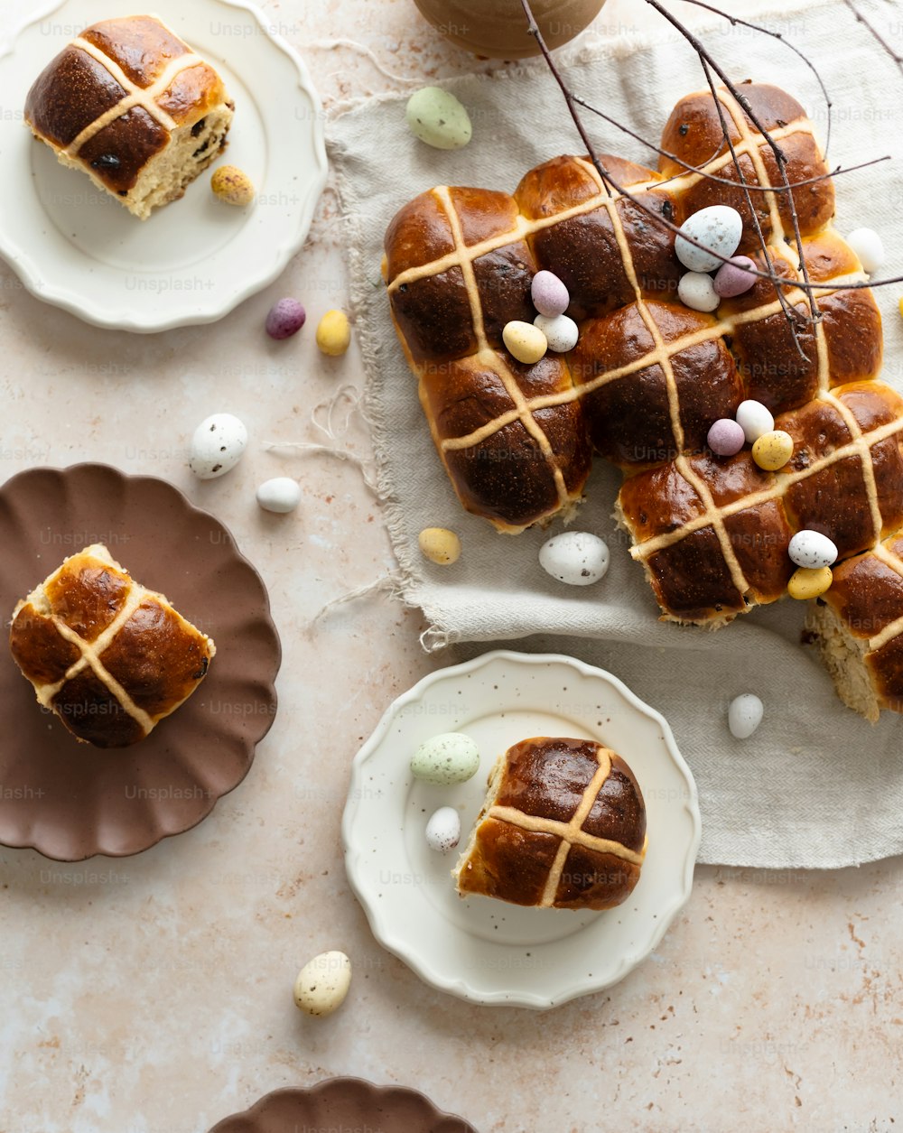 a table topped with plates of hot cross buns