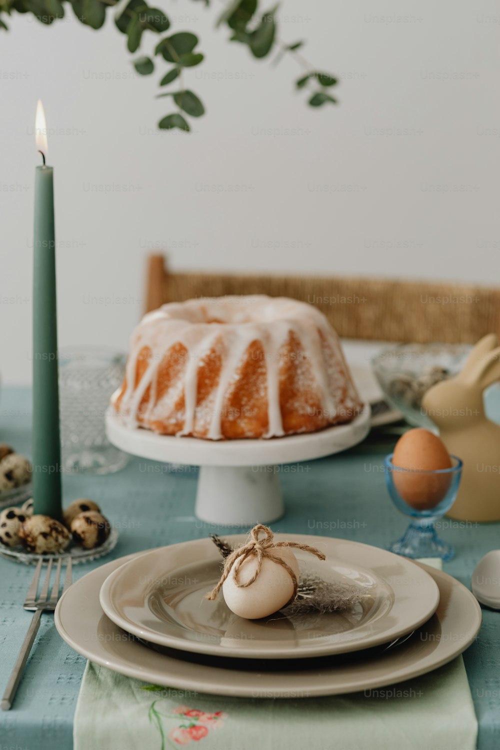 Una mesa cubierta con un pastel bundt junto a una vela