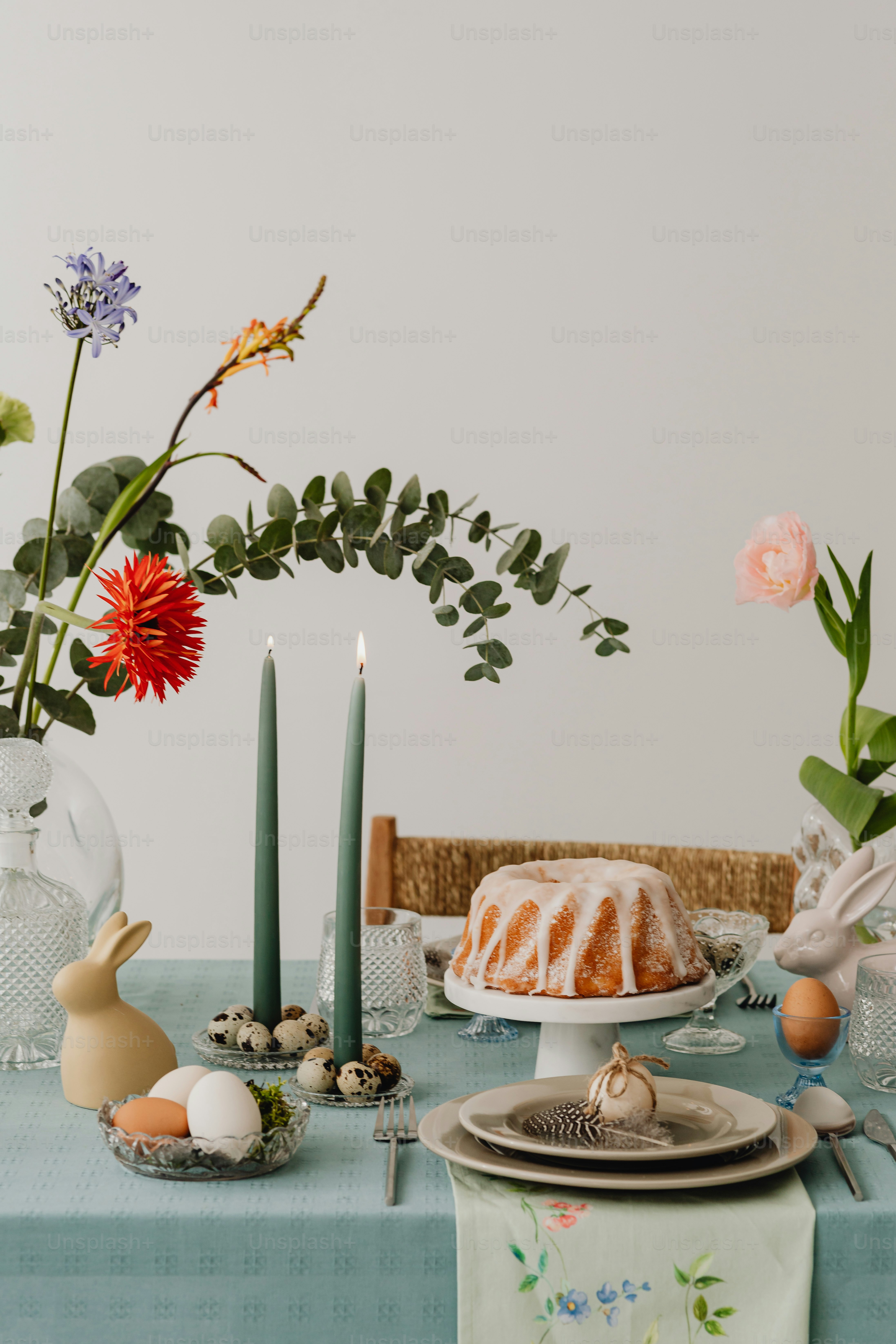 ein Tisch mit einem Kuchen neben einer Vase voller Blumen