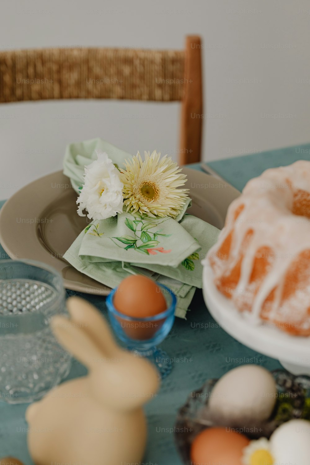 a table topped with a bundt cake next to a plate of eggs
