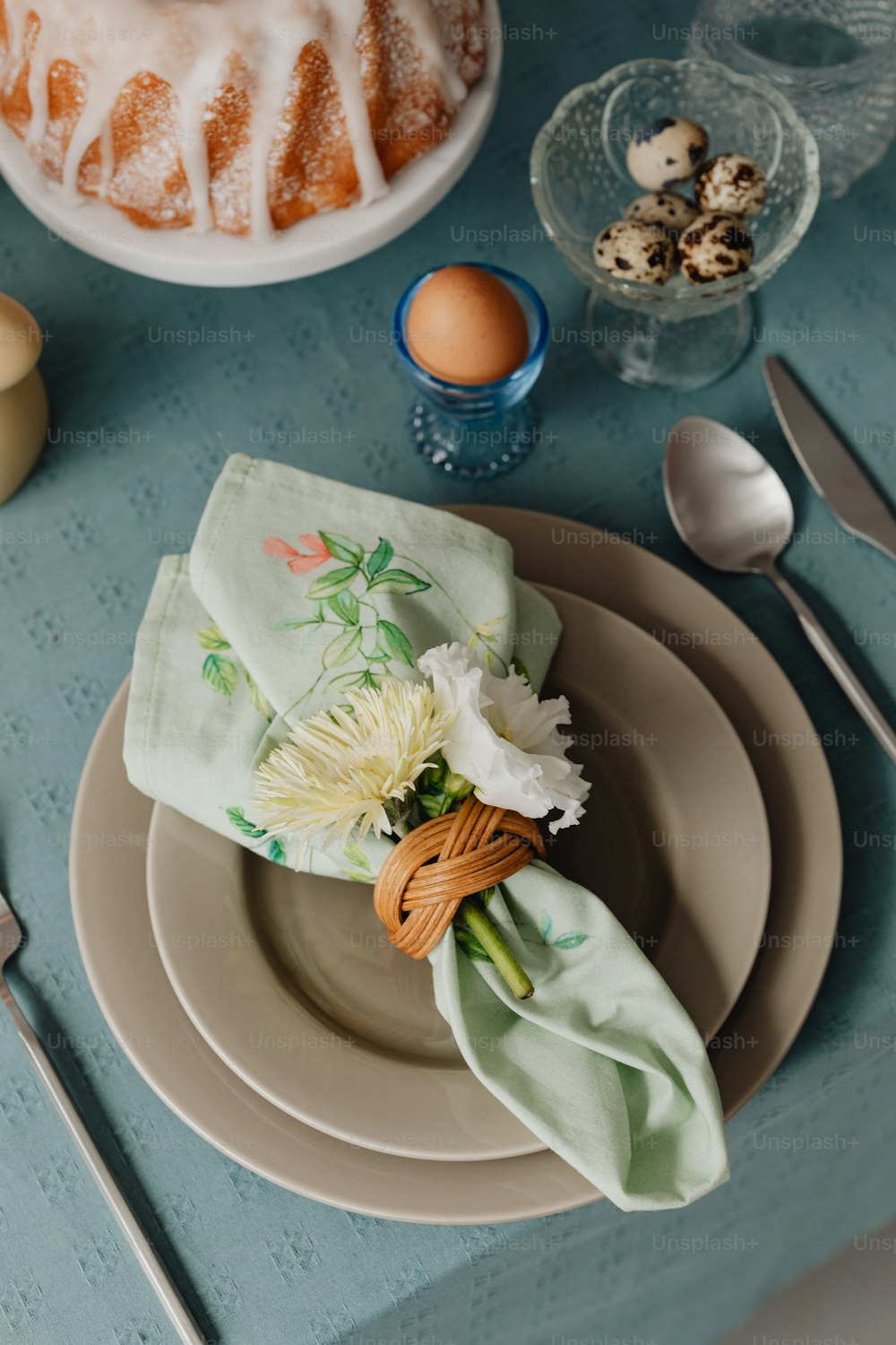 a table set with a cake and flowers on it