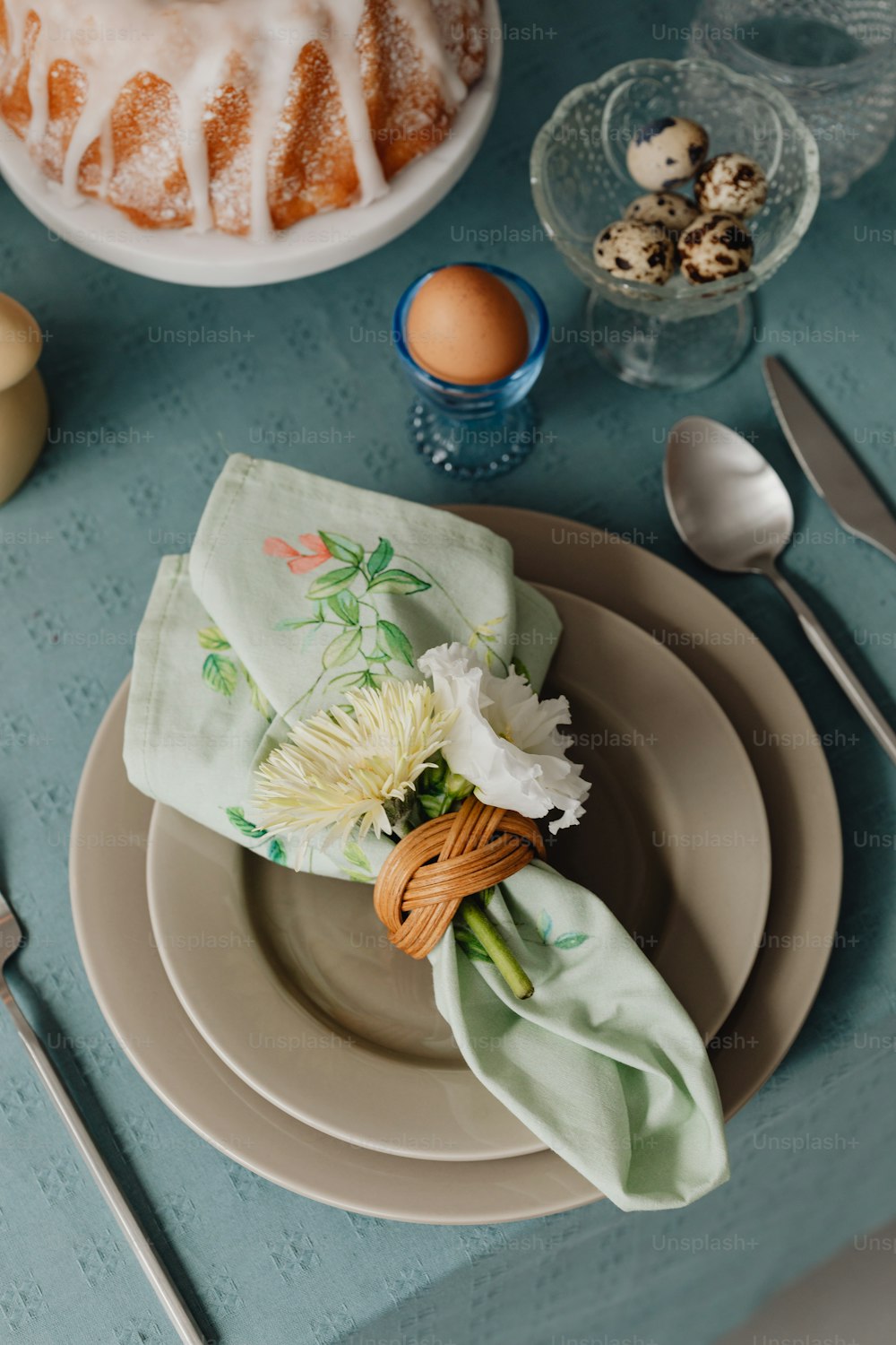 ein gedeckter Tisch mit einem Kuchen und Blumen darauf