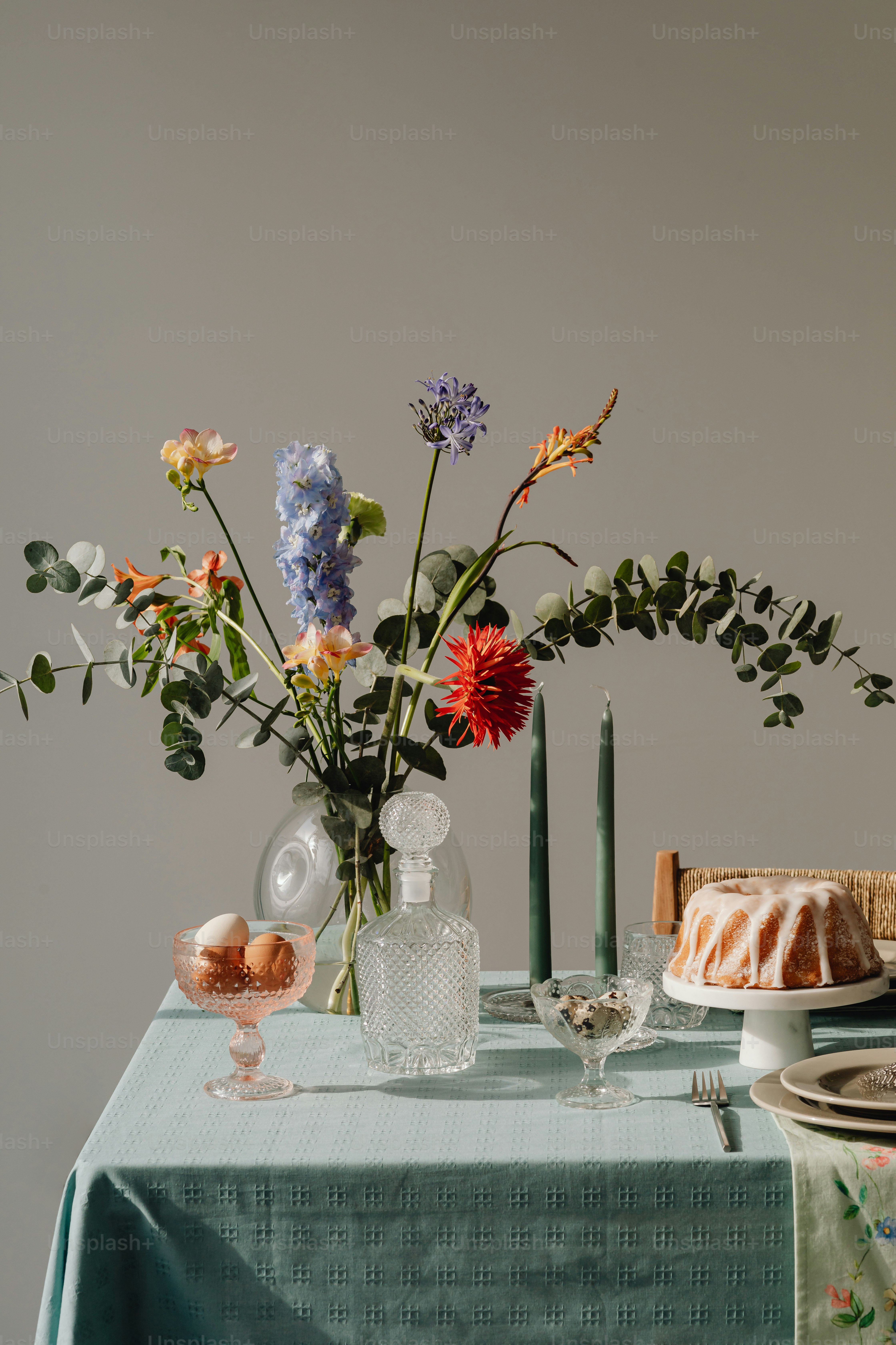 ein Tisch mit einem Kuchen und einer Vase voller Blumen