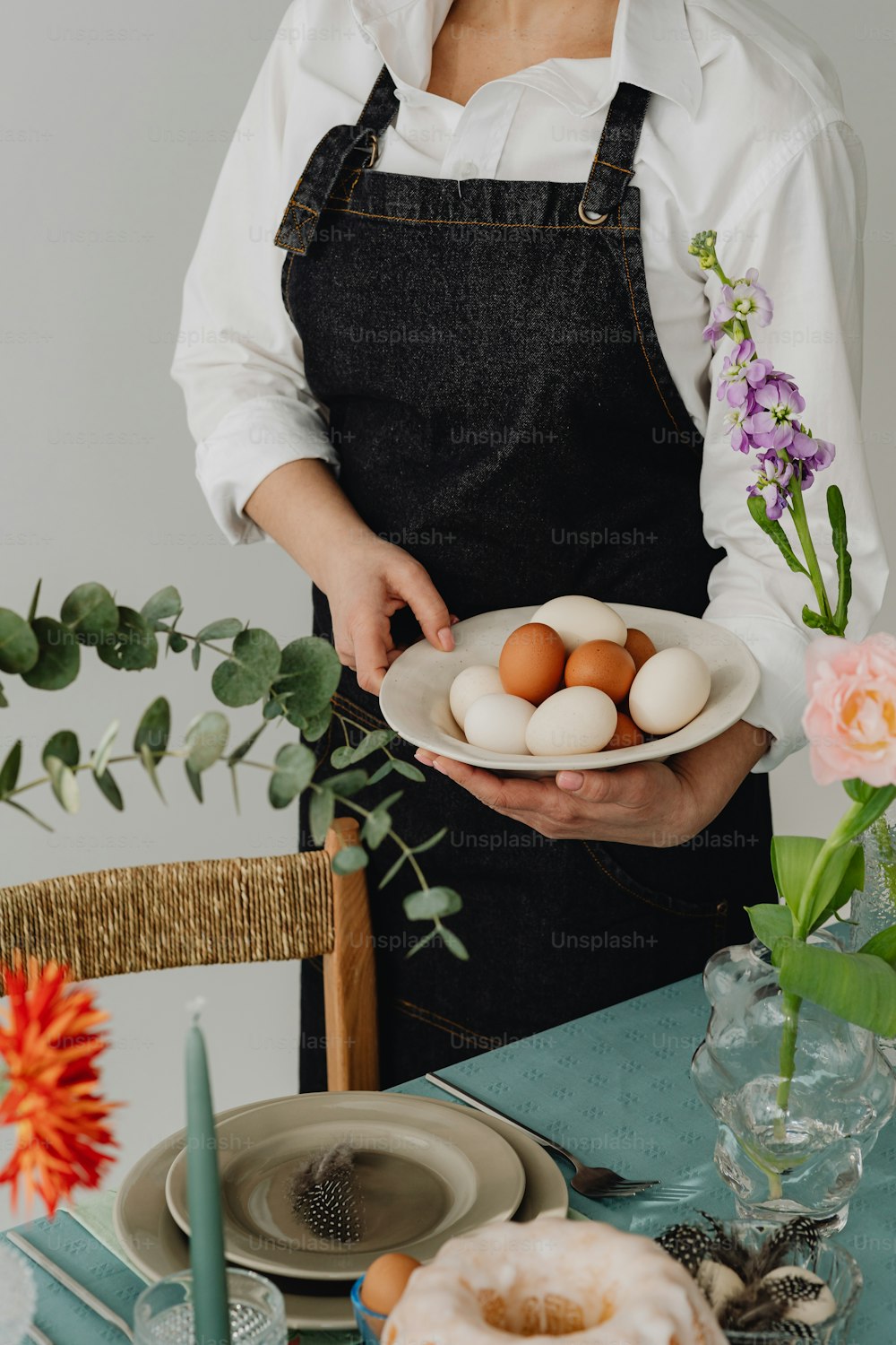 Une femme tenant une assiette d’œufs sur une table