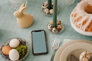 a table topped with plates of food and a phone