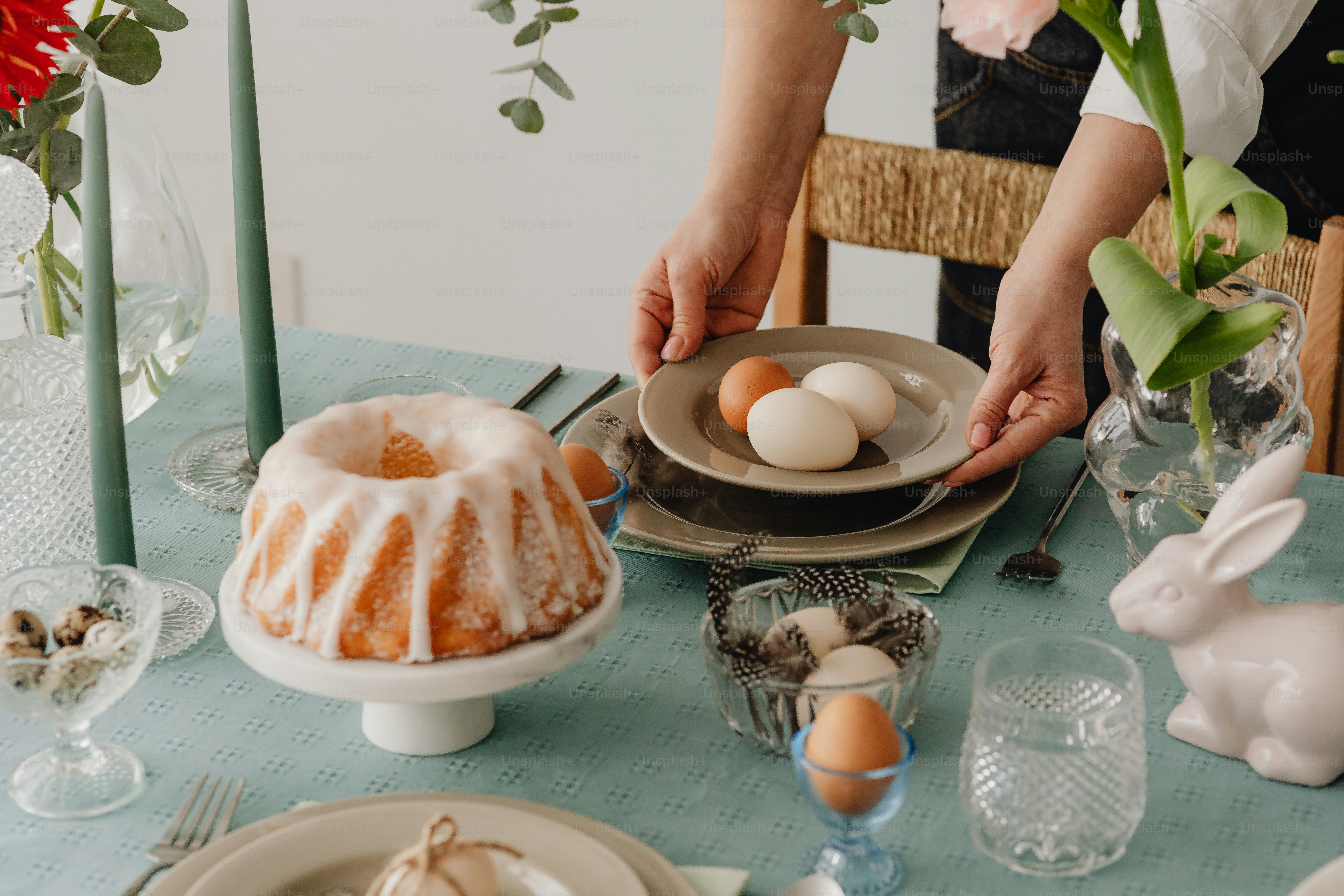 A table topped with a bundt cake covered in icing photo – Easter table ...