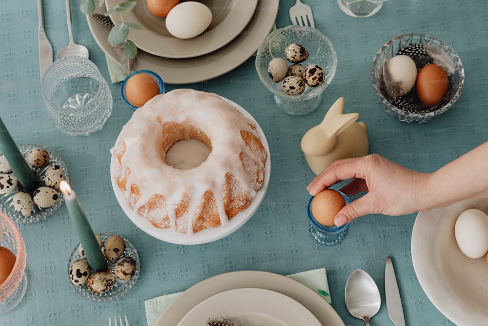 a person holding an egg in front of a bundt cake