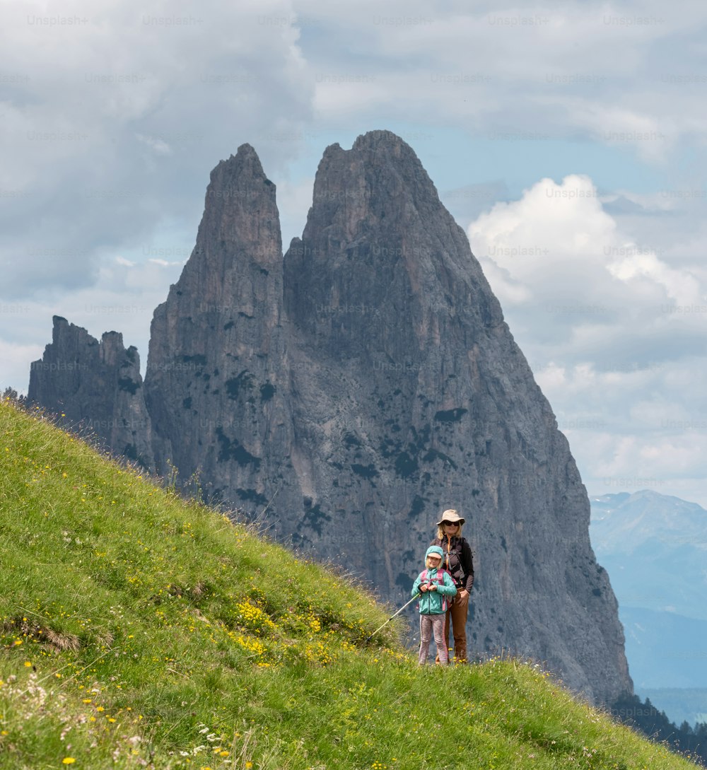 Una mujer y un niño están parados en una colina cubierta de hierba