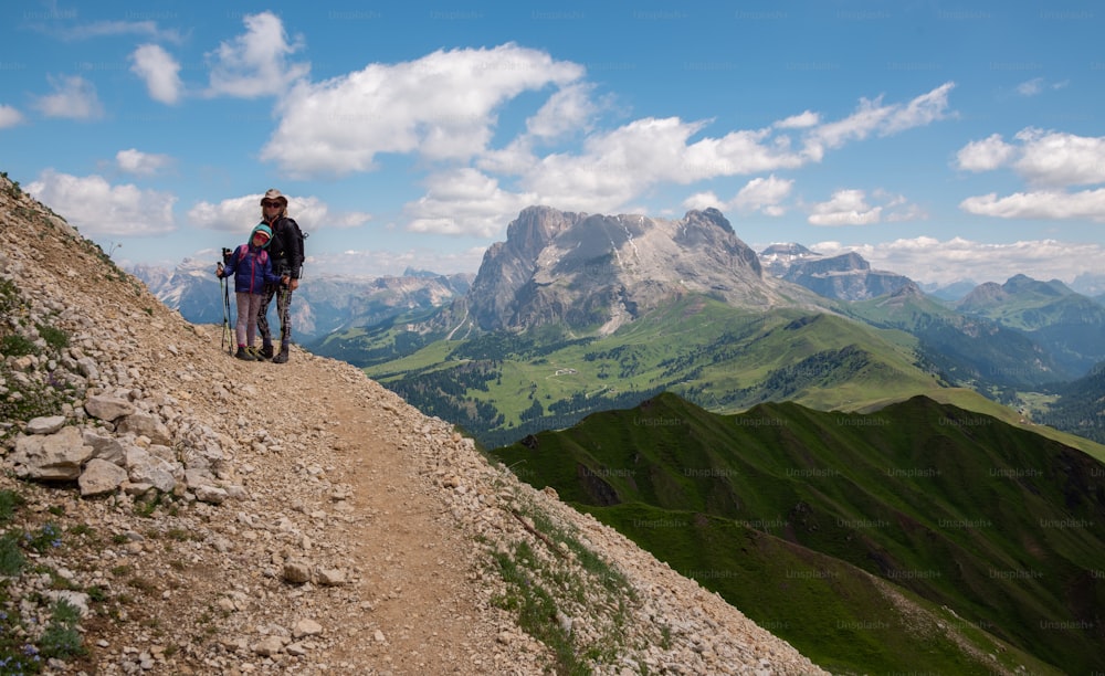 um par de pessoas em pé no topo de uma montanha