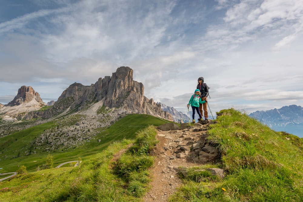 a couple of people standing on top of a lush green hillside