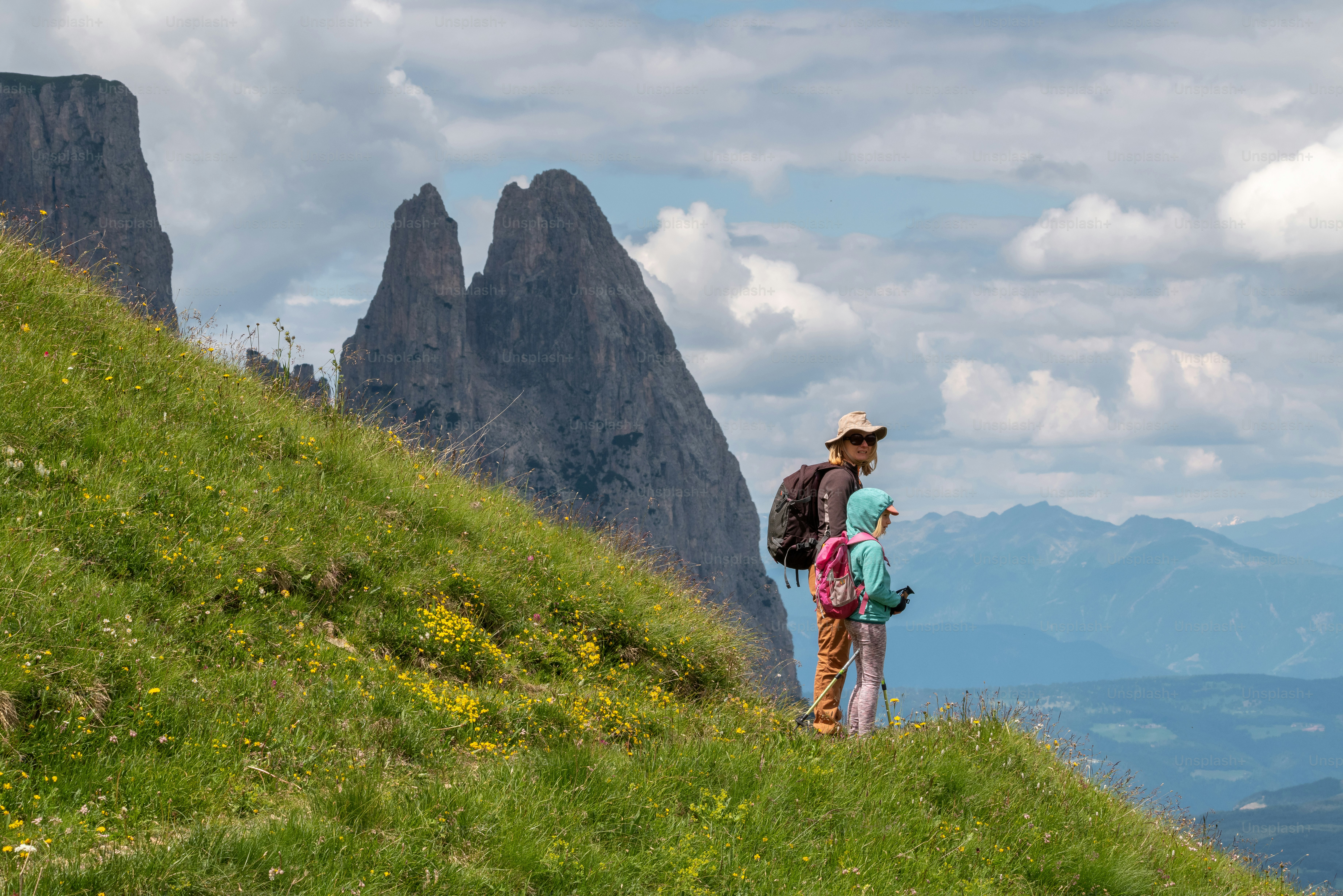 a man standing on top of a lush green hillside