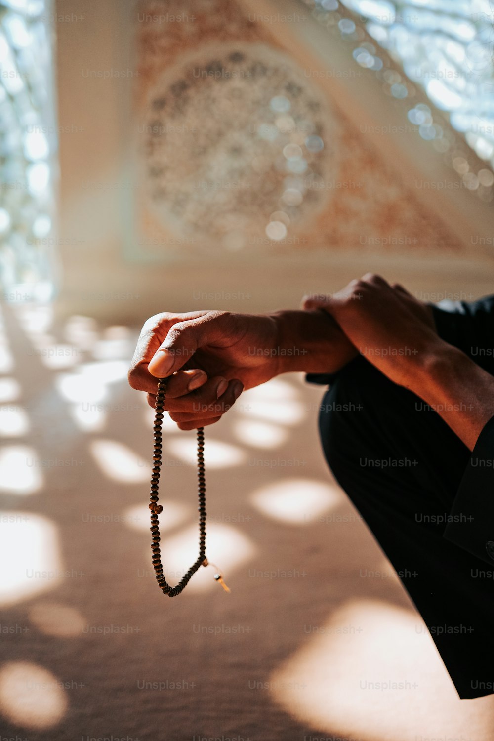 a man kneeling down holding a rosary in his hand