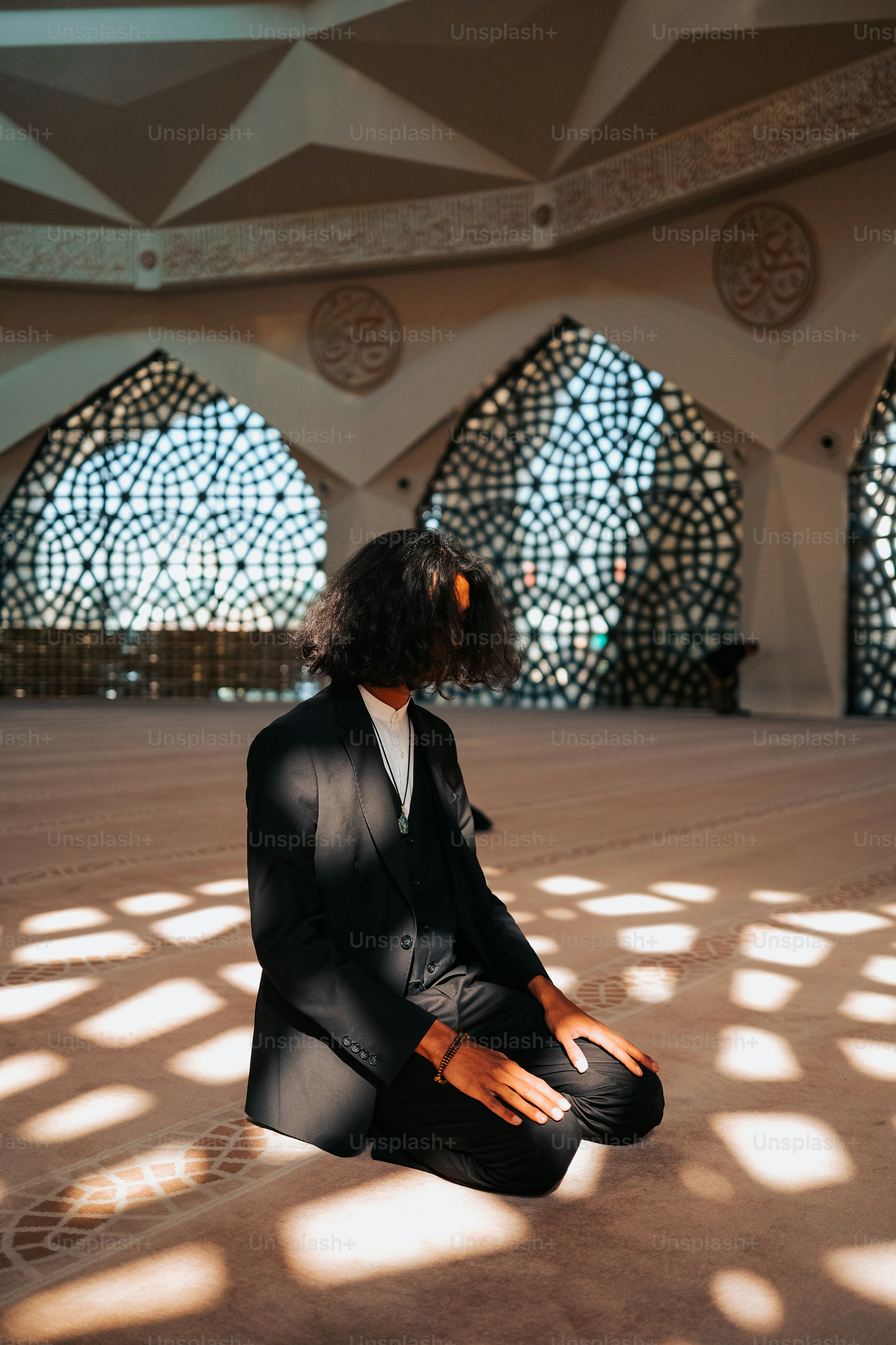 a woman in a suit sitting on the floor