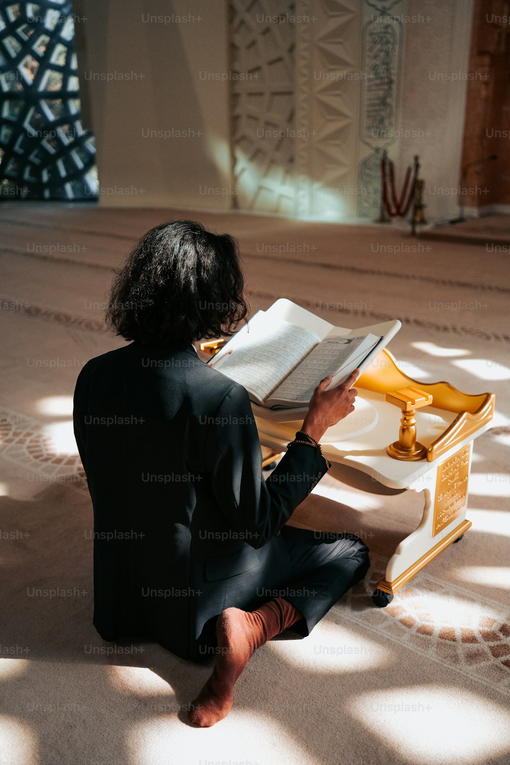uma pessoa sentada no chão lendo um livro
