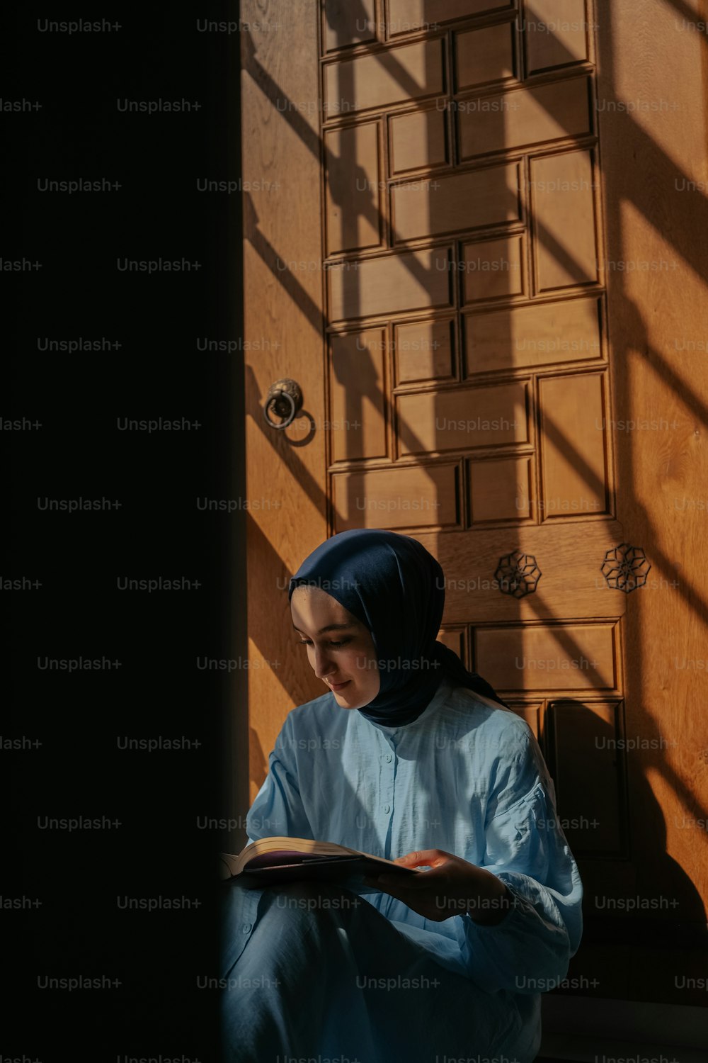 a woman sitting on the floor reading a book