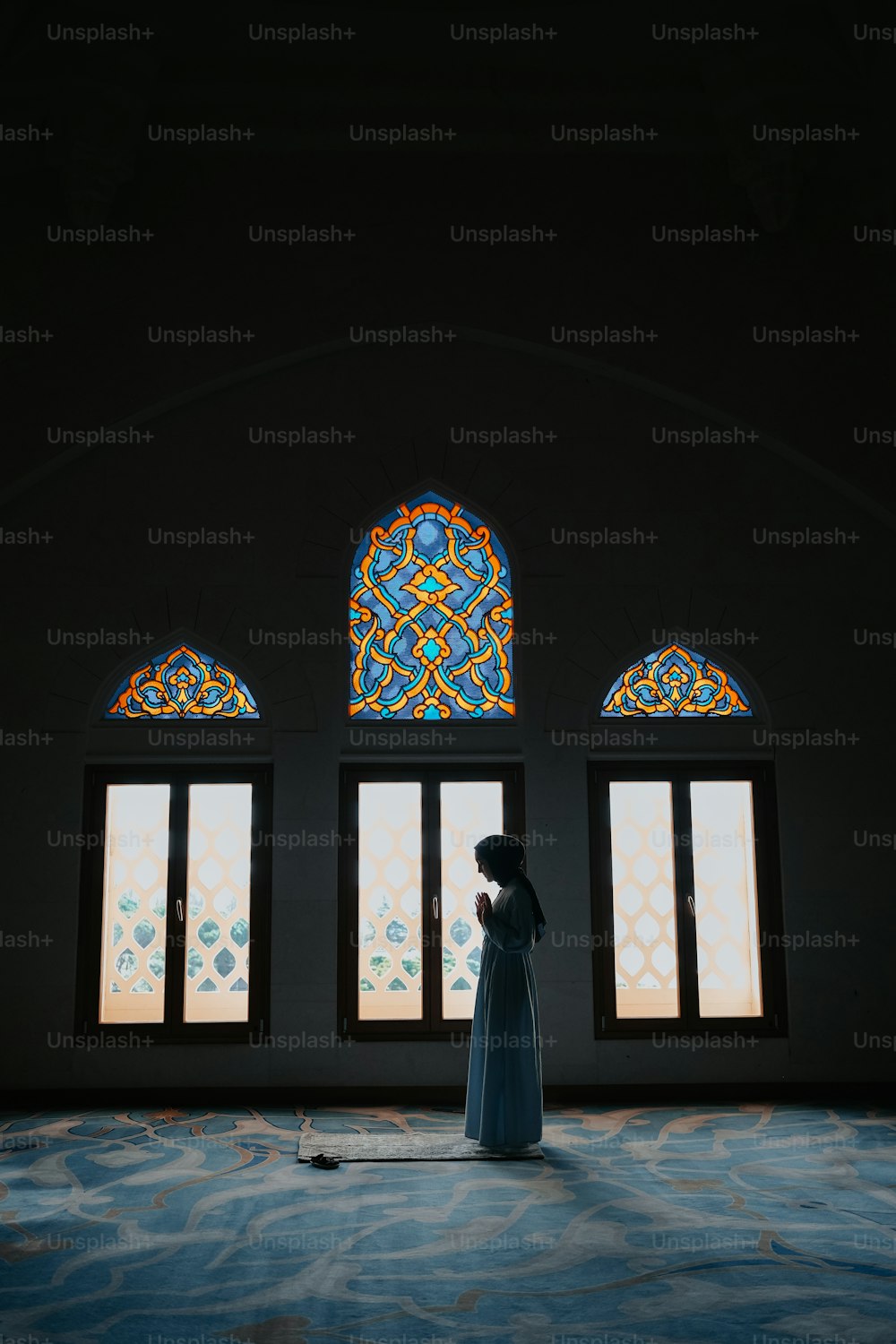 a woman standing in front of a stained glass window