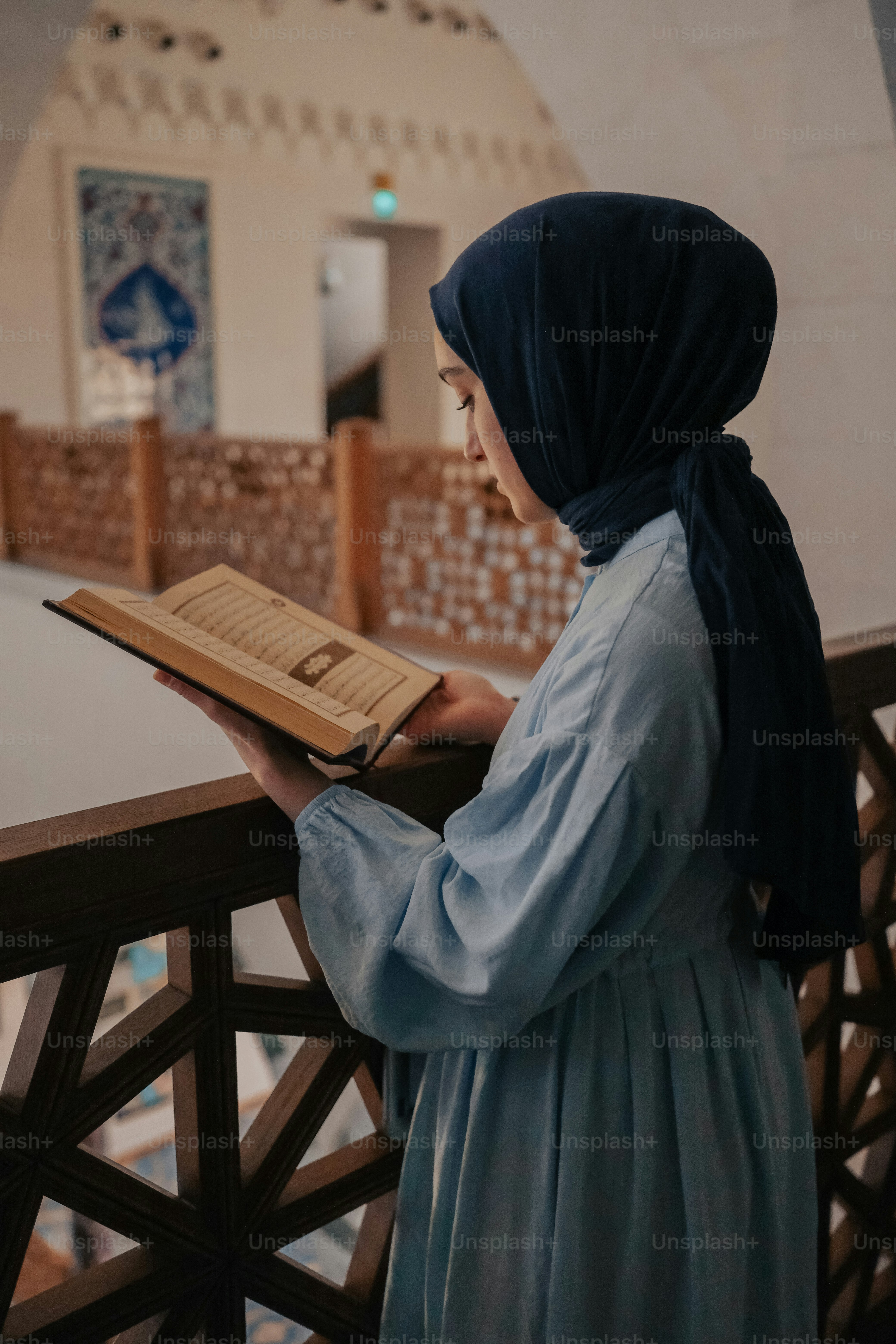 a woman in a blue dress is reading a book