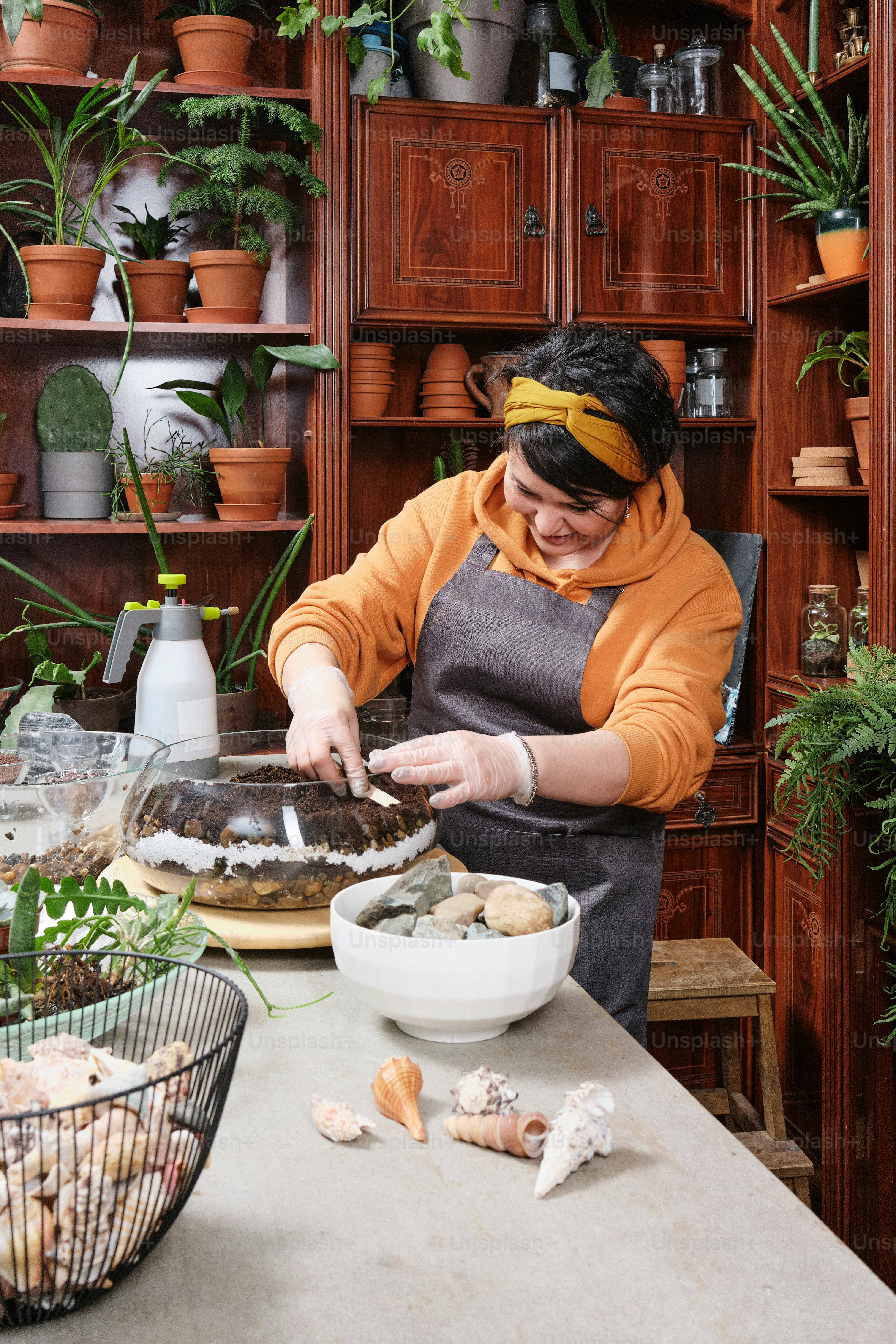Eine Frau in einem orangefarbenen Hemd bereitet Essen zu