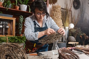Eine Frau arbeitet an einem Stück Treibholz