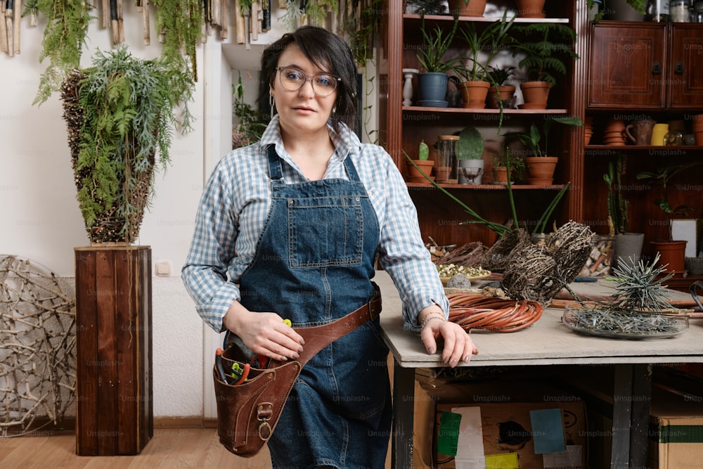 a woman is holding a tool belt in a room full of potted plants