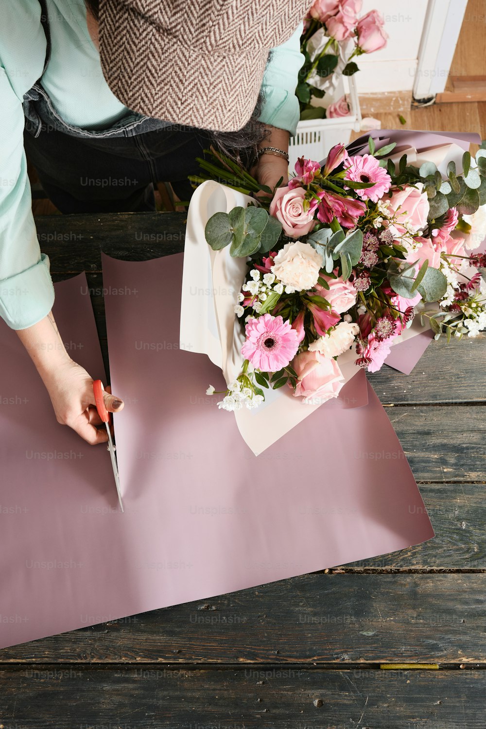 a woman cutting a bouquet of flowers on a piece of paper