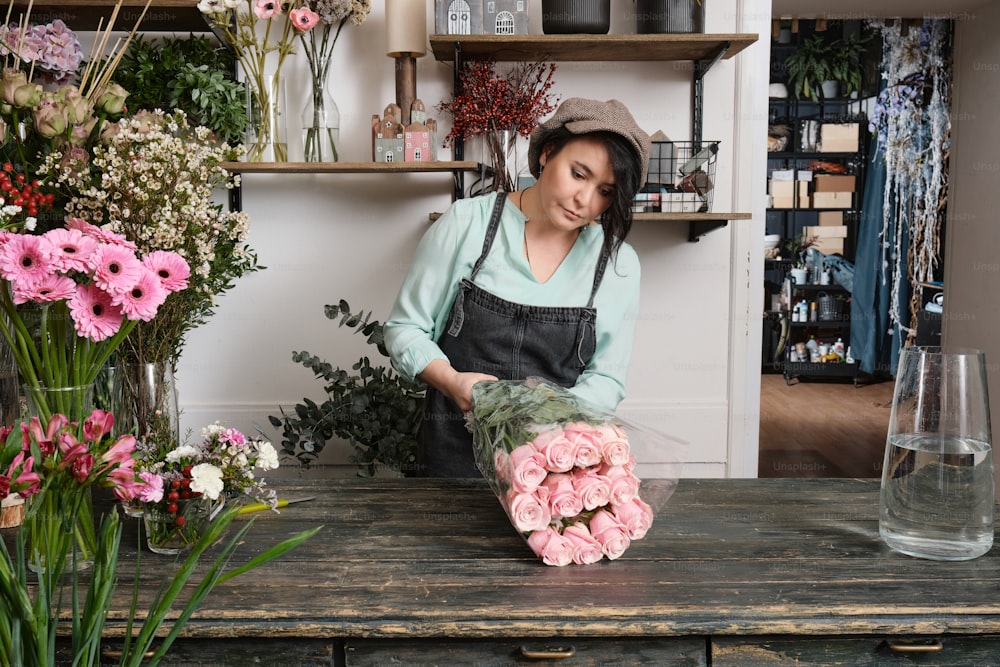uma mulher que organiza as flores em uma floricultura