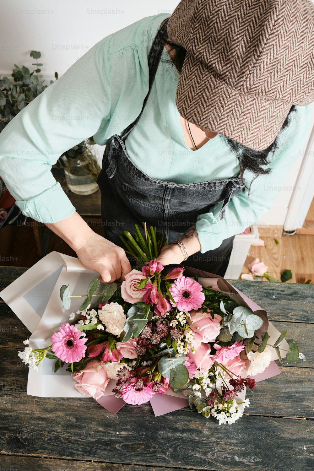 a woman arranging a bouquet of flowers on a table