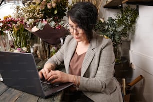 a woman sitting at a table using a laptop computer