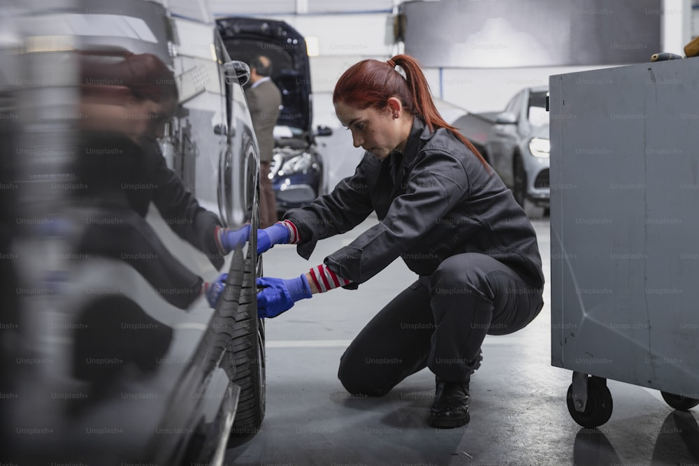 a woman working on a car in a garage