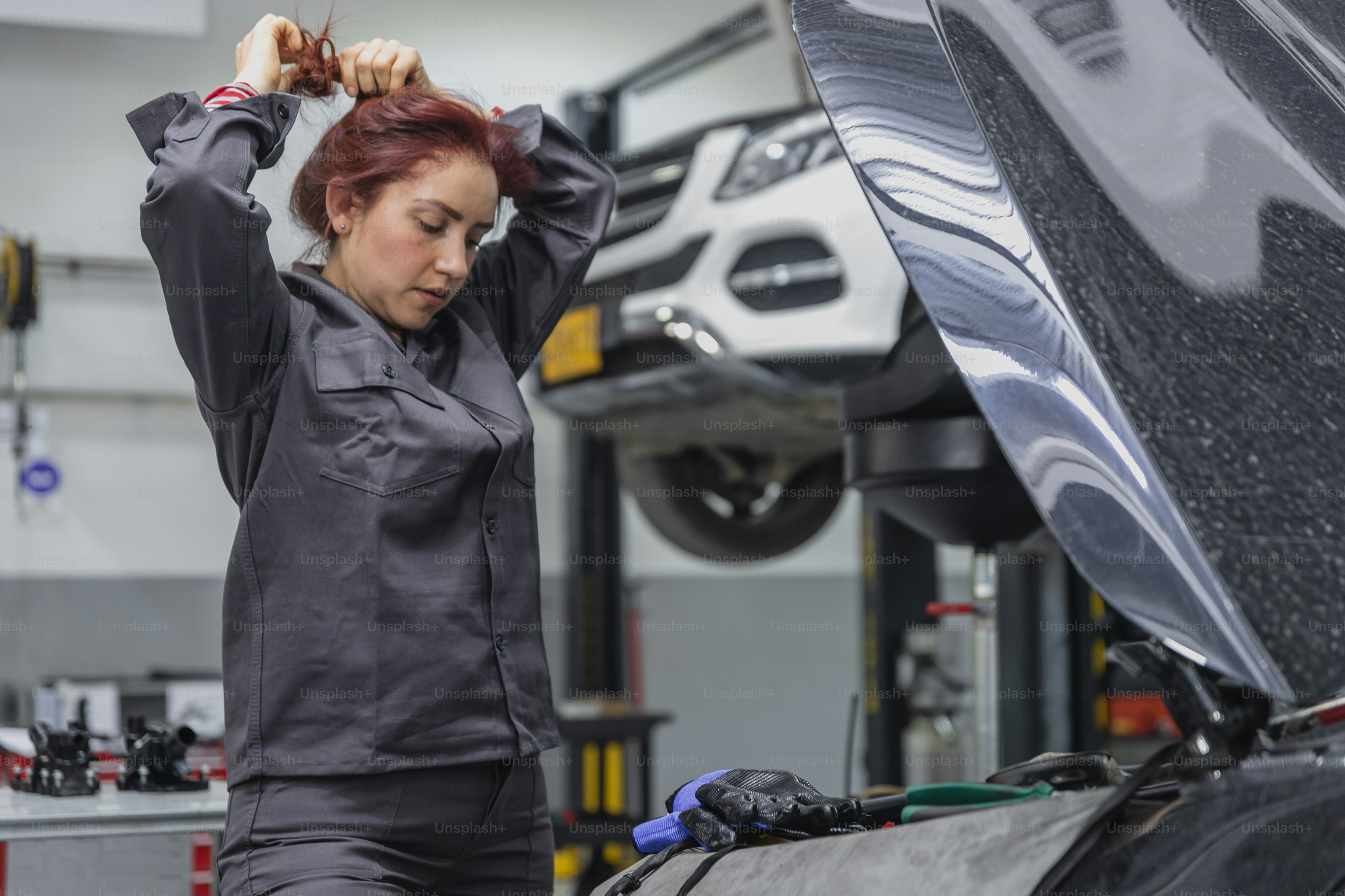 A woman working on a car in a garage photo – Car Image on Unsplash