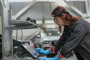 a woman wearing goggles and gloves working on a laptop