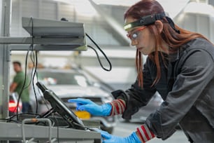 uma mulher que usa óculos e luvas que trabalham em uma máquina