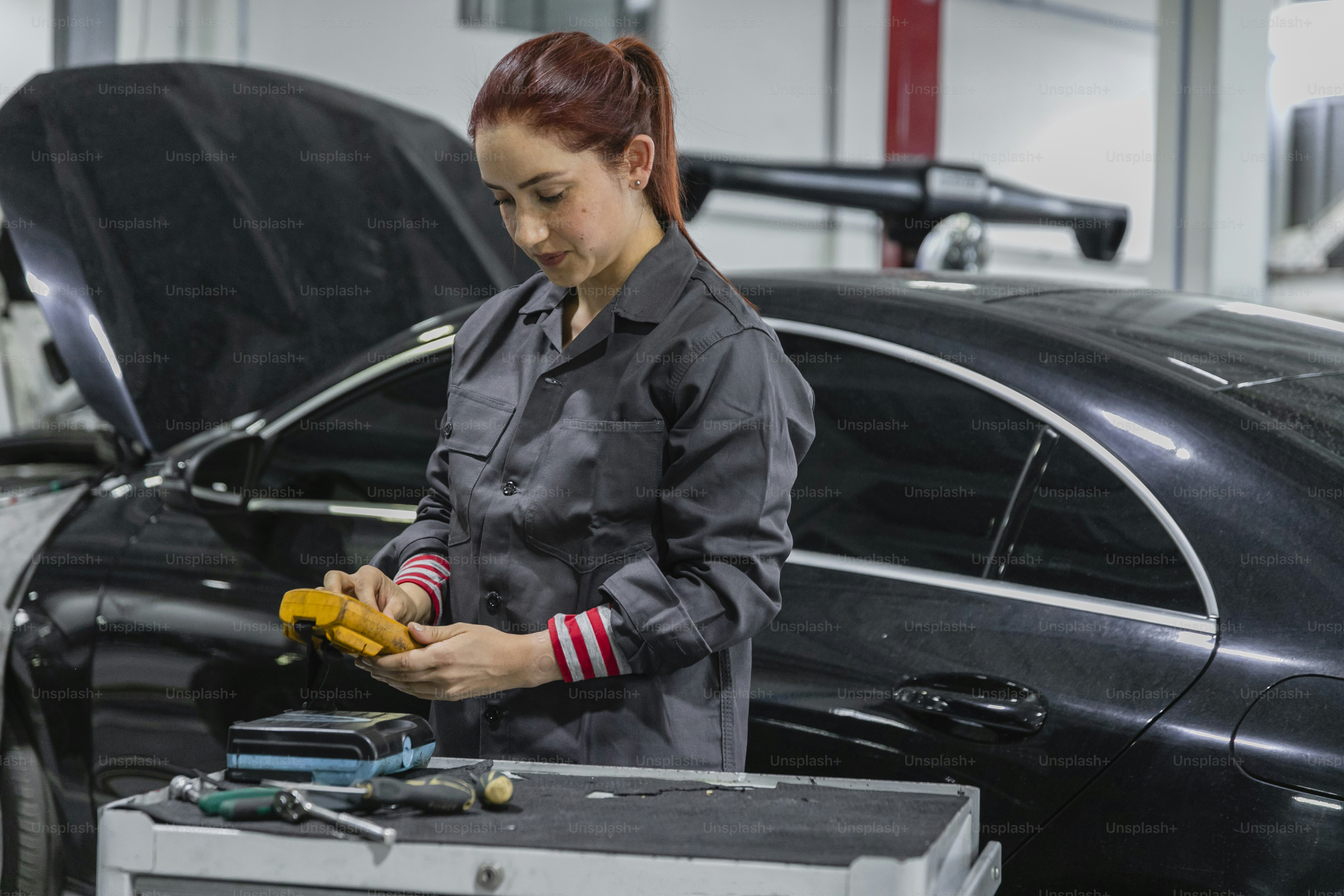 Two women working on a car in a garage photo – Woman Image on Unsplash