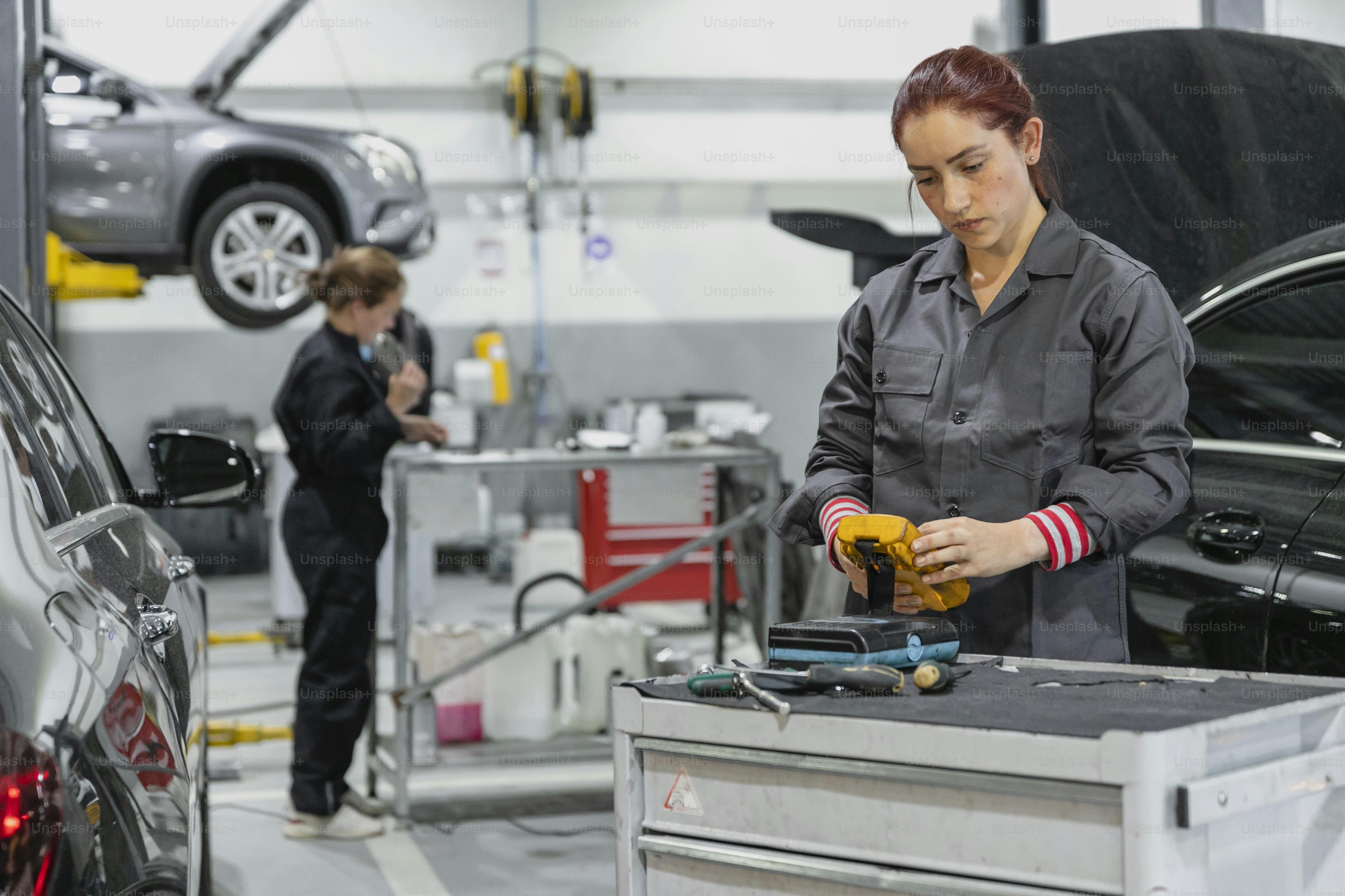 a woman working on a car in a garage