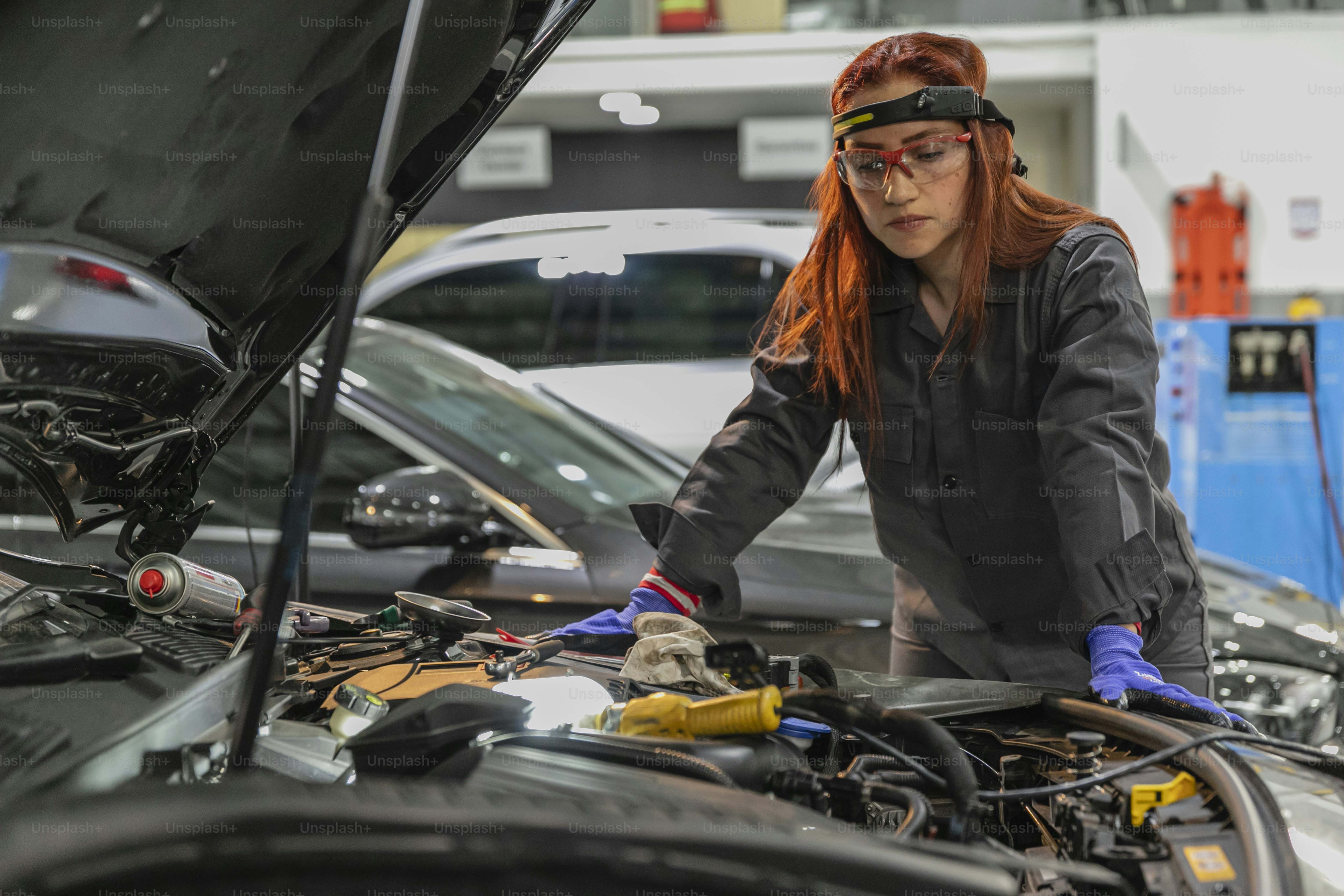 A woman working on a car in a garage photo – Car Image on Unsplash