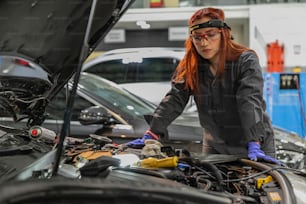 Una mujer trabajando en un coche en un garaje