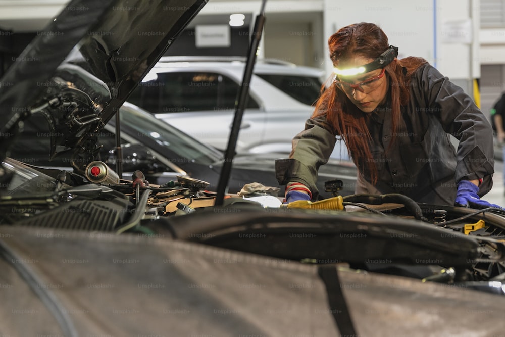 a woman working on a car in a garage