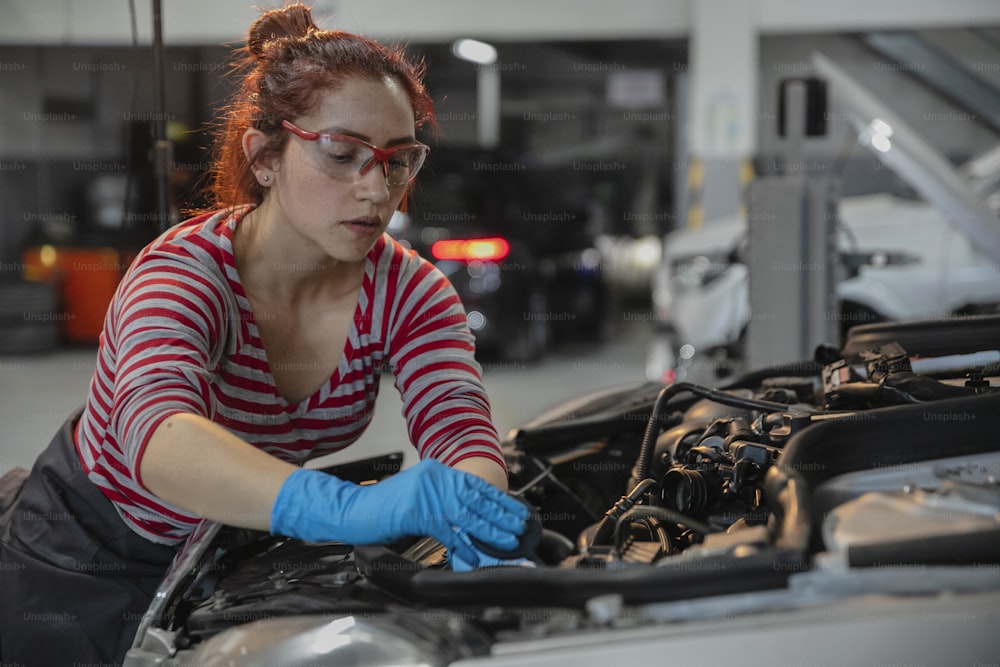 a woman working on a car in a garage