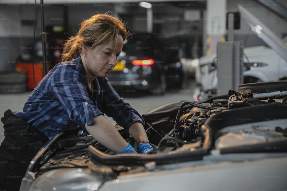 a woman working on a car in a garage