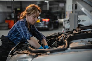 a woman working on a car in a garage