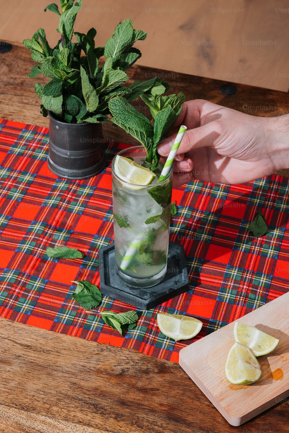 a person holding a green drink with lemons and mint