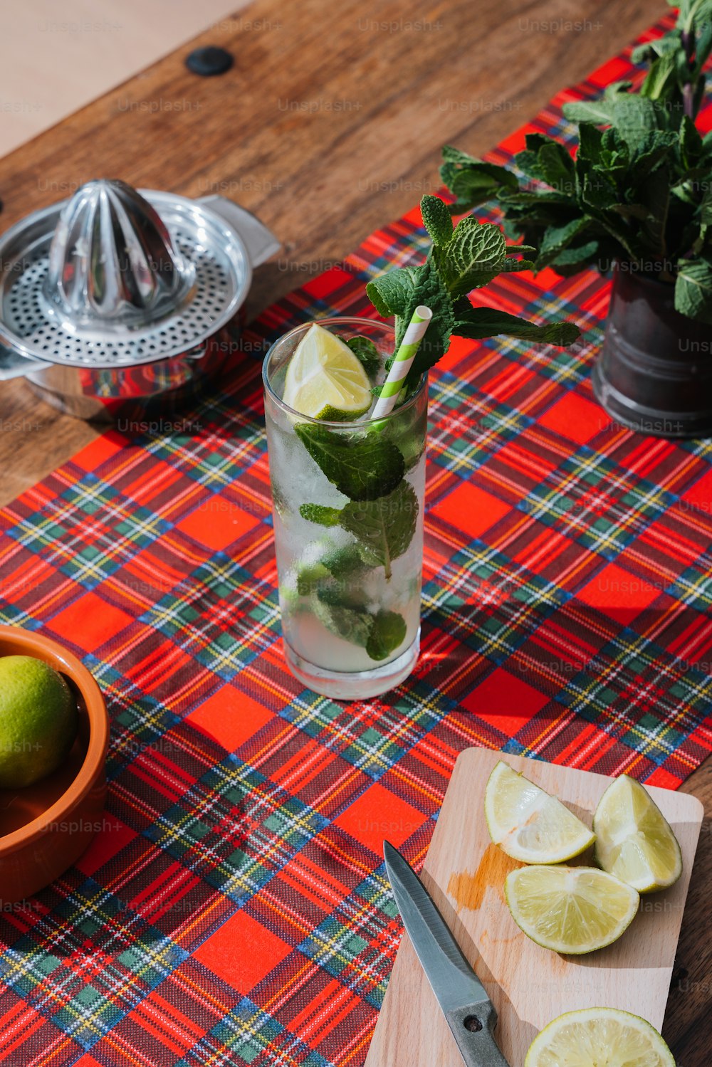 a table topped with a glass of lemonade and limes