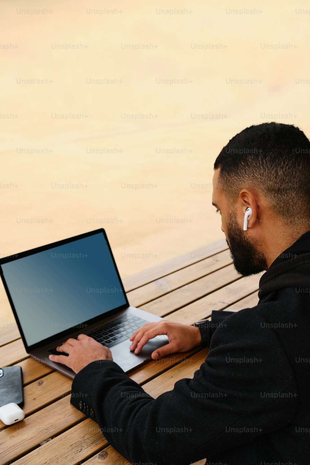 ノートパソ�コンを使ってベンチに座っている男性