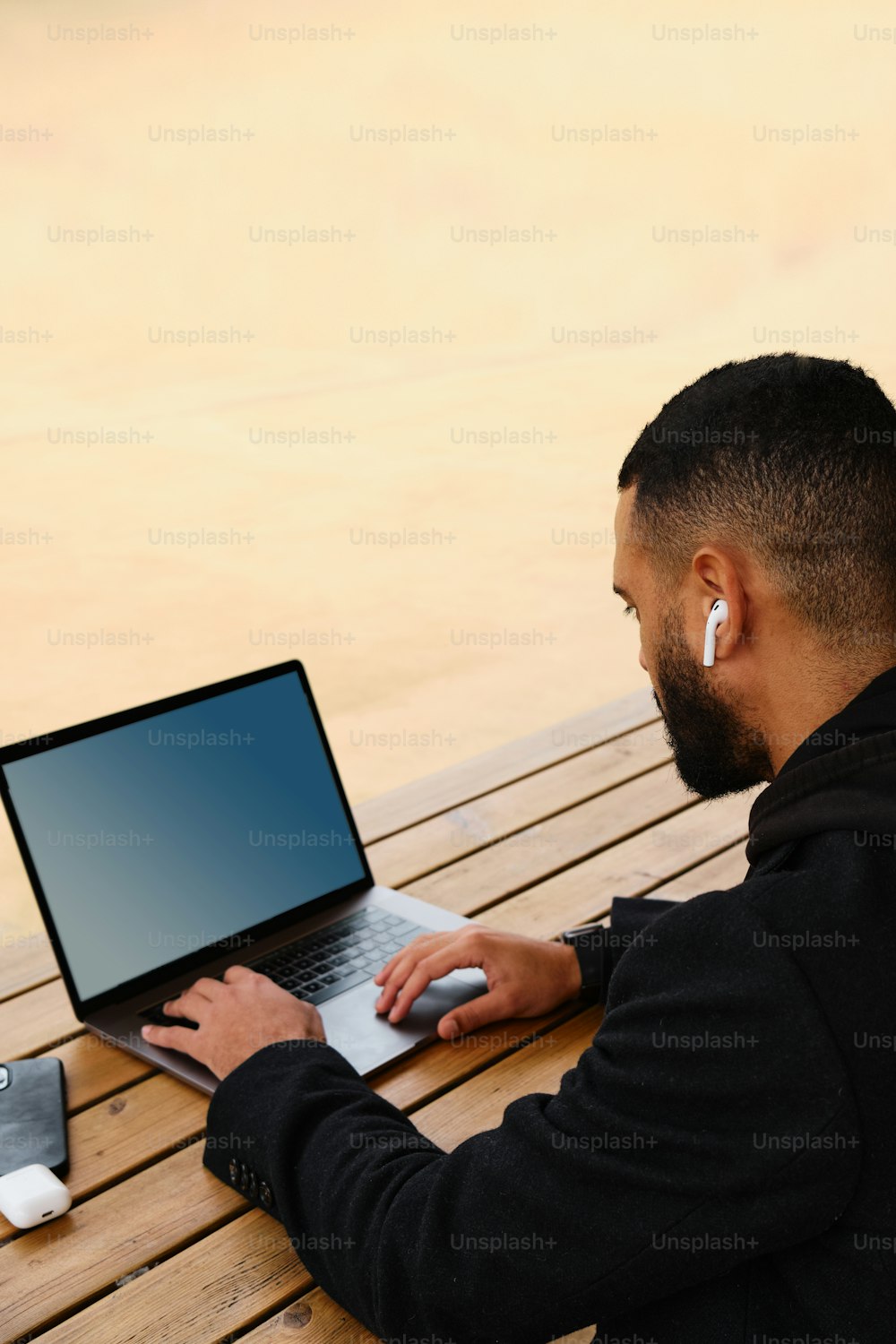 a man sitting on a bench using a laptop computer