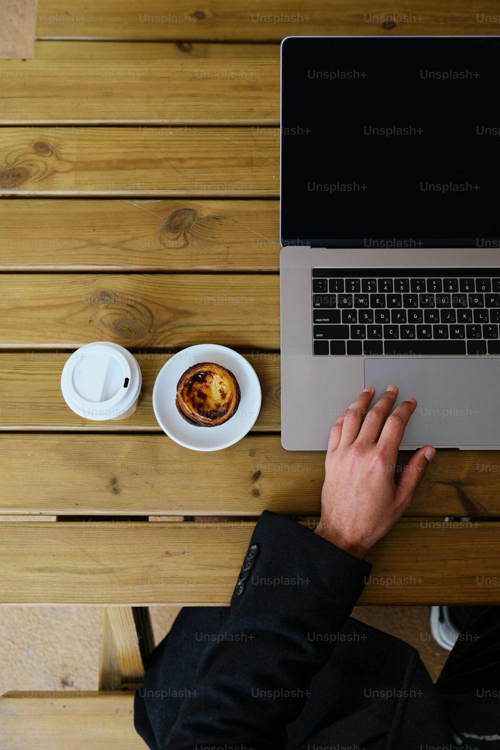 a person using a laptop on a wooden table